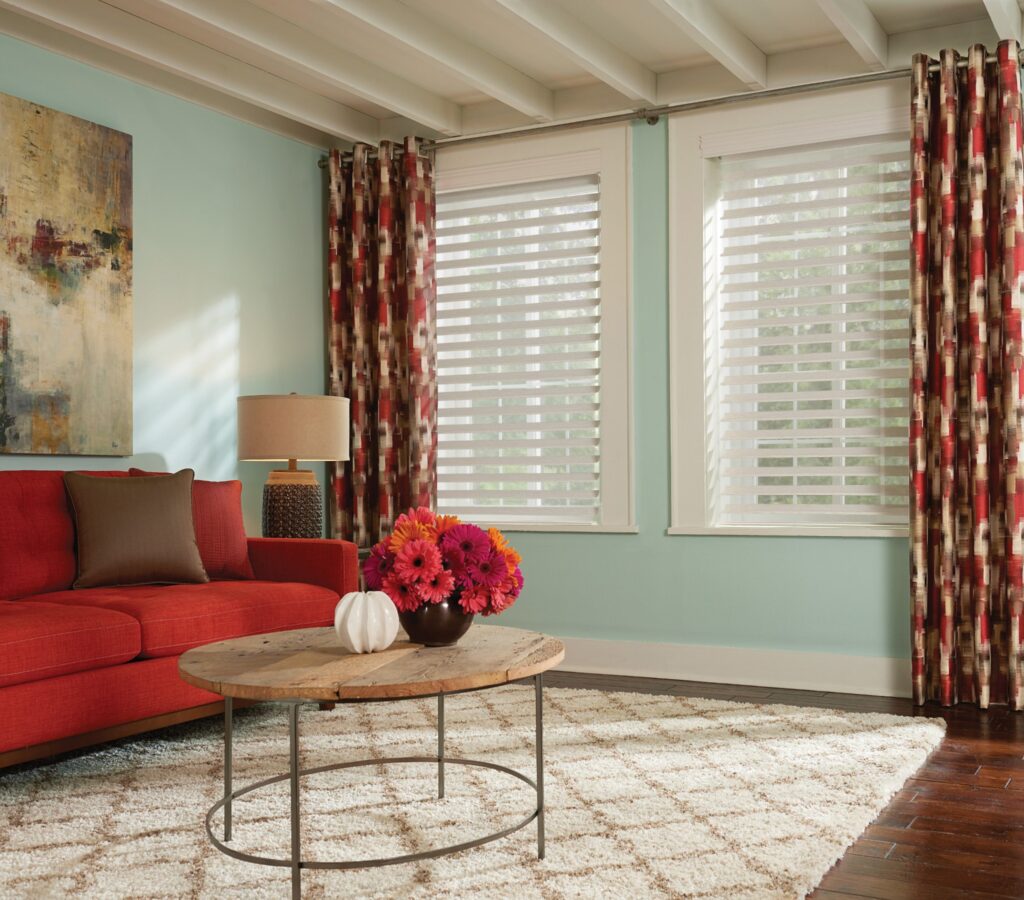 Living room with red floral curtains and red orange sofa.  